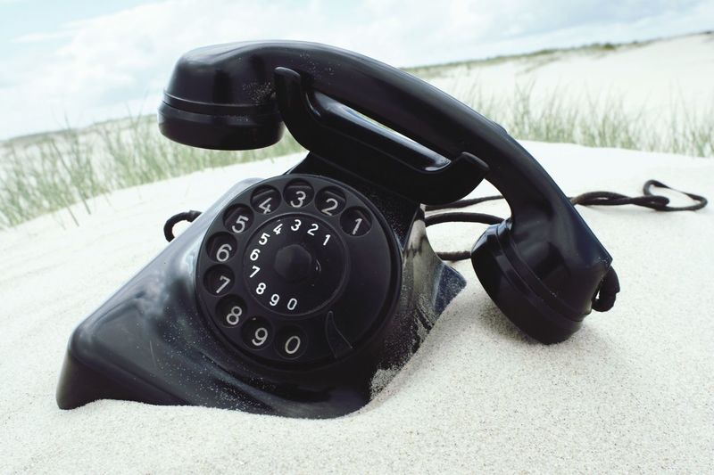 Close-up of retro telephone on sand