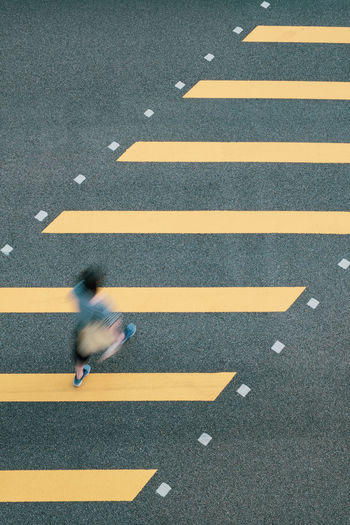 High angle view of woman crossing on road in city