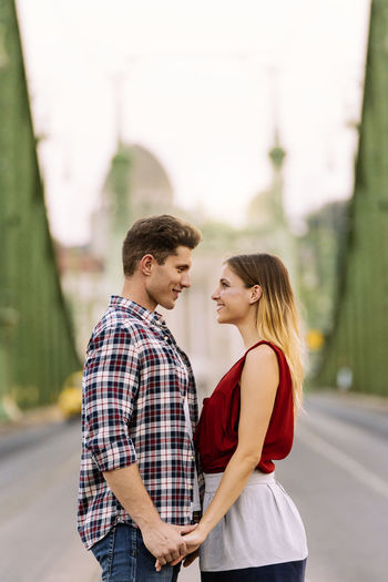 Side view of couple standing in city