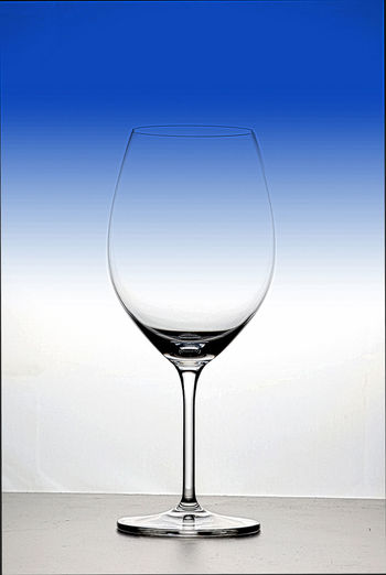 Wineglass on table against white background