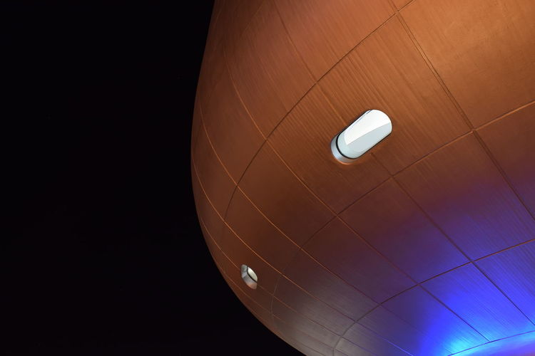 Low angle view of illuminated pendant light against sky