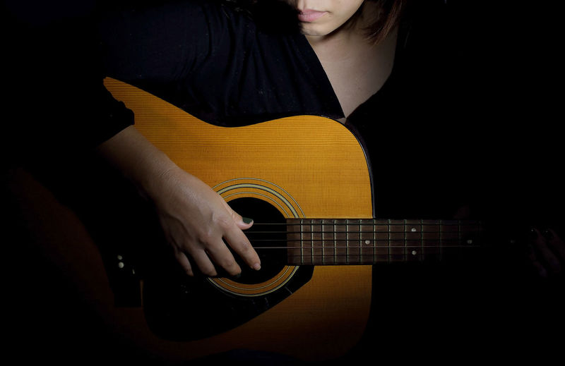 Close-up of woman playing guitar