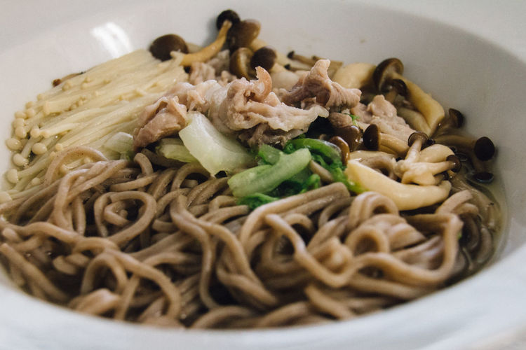 Close-up of soba noodles with mushrooms served in bowl