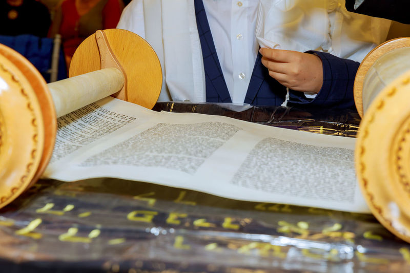 Midsection of person by torah at synagogue
