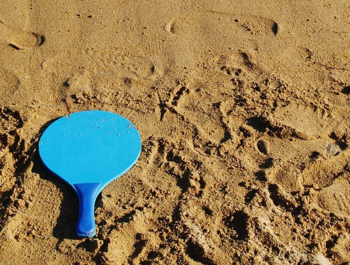 High angle view of table tennis racket at sandy beach