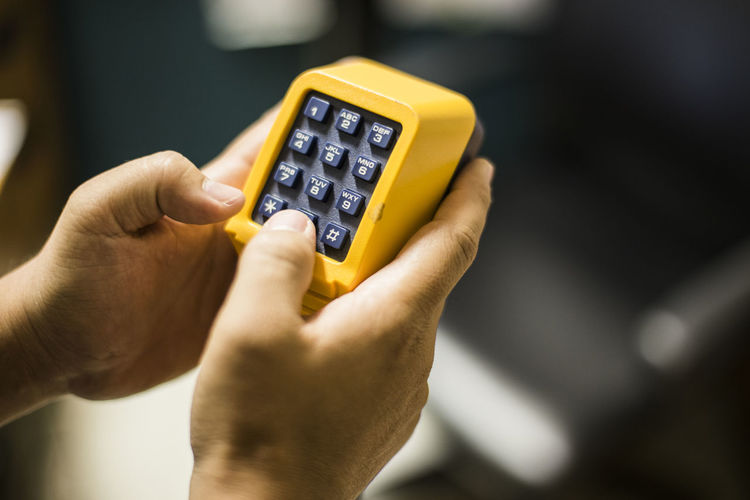 Cropped image of hands holding old-fashioned mobile phone