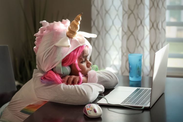 Midsection of girl wearing costumes using laptop at home. 
