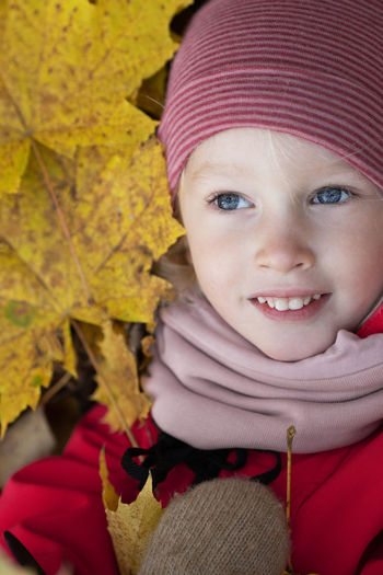Portrait of cute girl with leaves during autumn