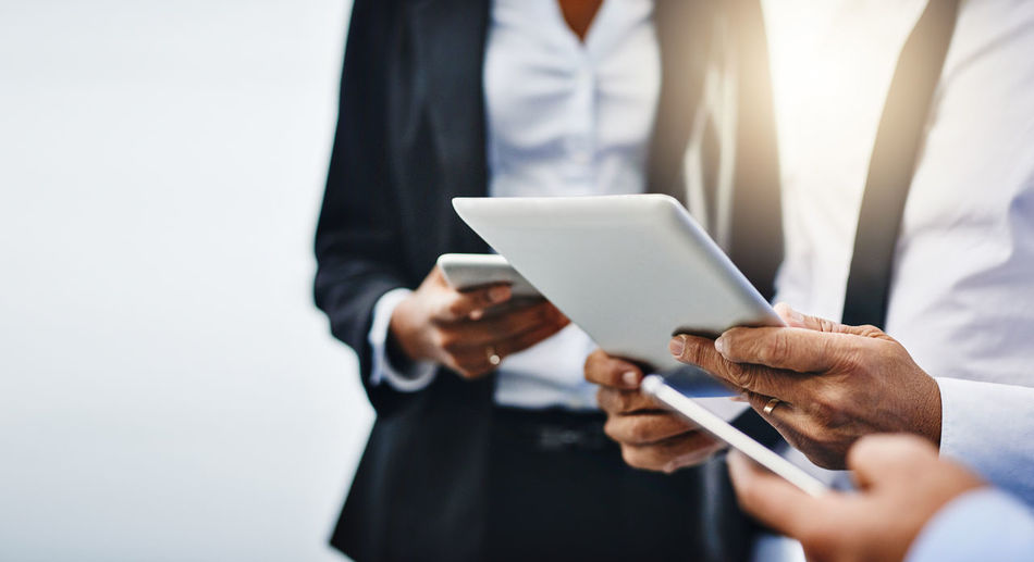 Midsection of businessman using mobile phone against white background