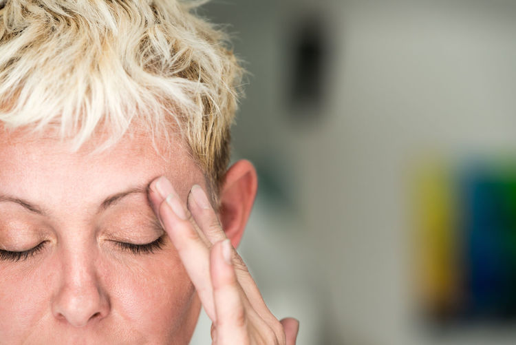Close-up of blond woman with headache