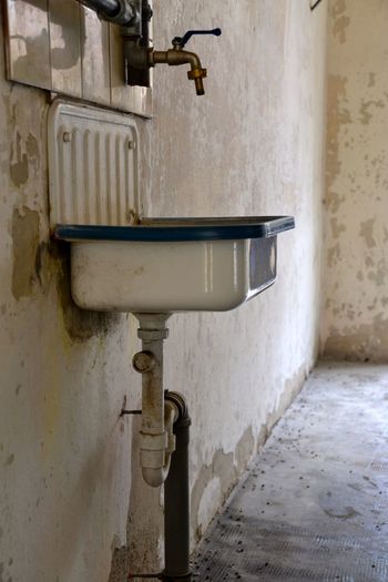 Sink and tap against run down wall