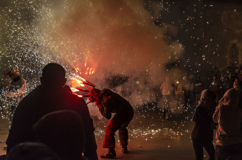 Group of people watching fire stunt at night
