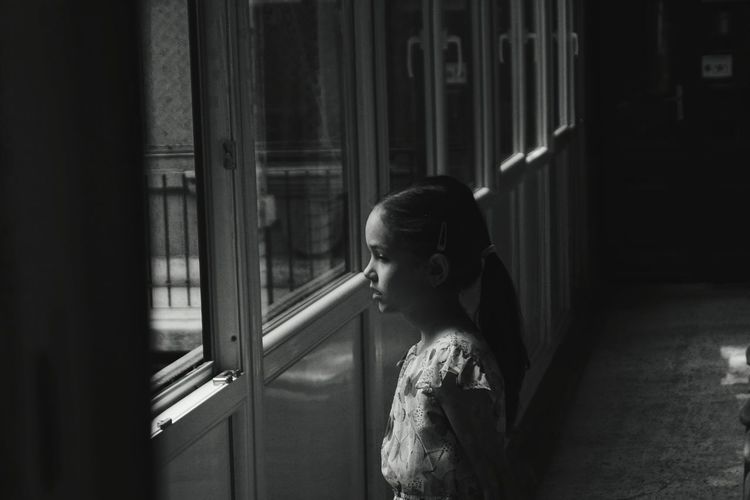 Girl standing by window at home