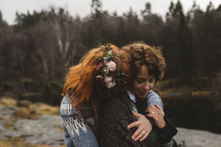 Lesbian couple embracing at lakeshore