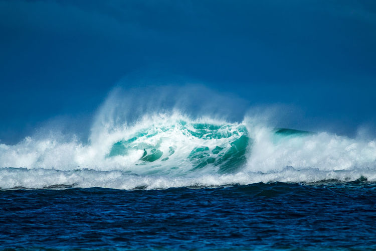 Wave in sea against blue sky
