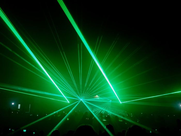 Green illuminated light beams in darkroom
