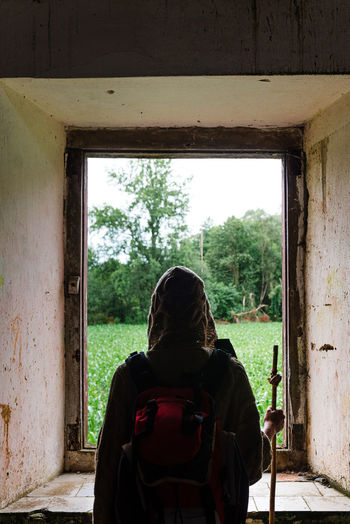 Rear view of woman sitting in abandoned window