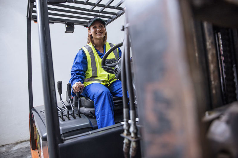 Smiling woman on forklift