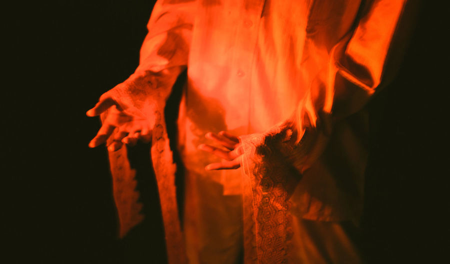 Close-up of hands against fire