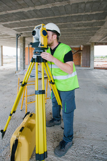 Surveyor engineer working at construction site with measuring equipment (total station)