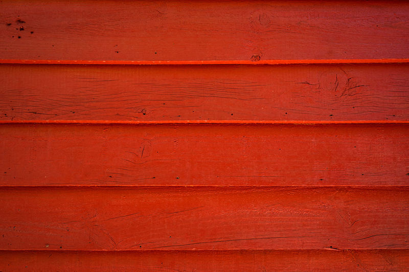 Front view of an exterior wood wall painted red.