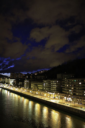 View of city at waterfront at night