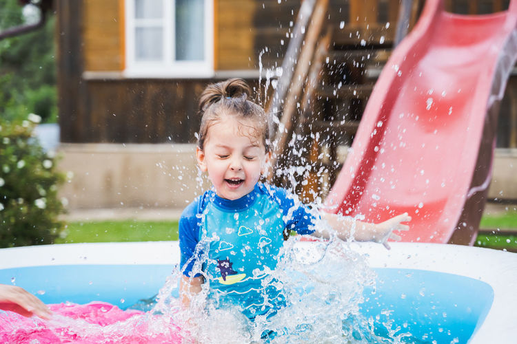 Girl playing in inflatable tub
