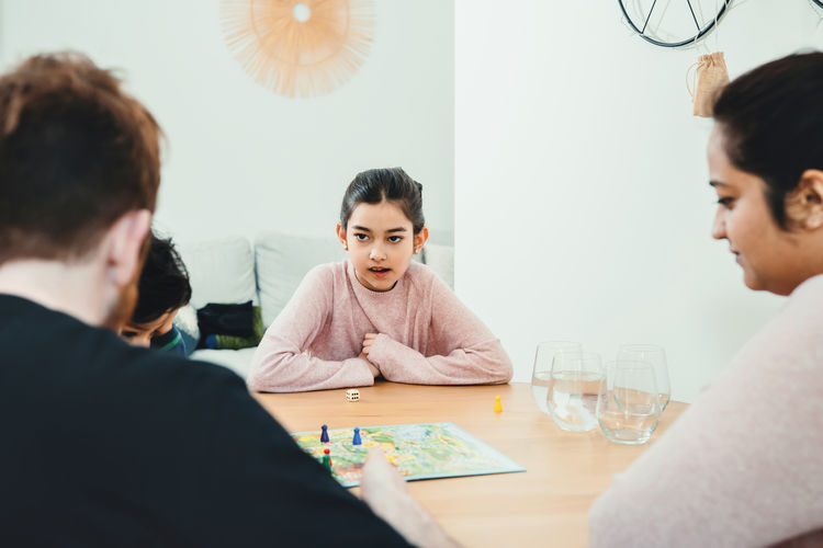 Family playing game on table at home