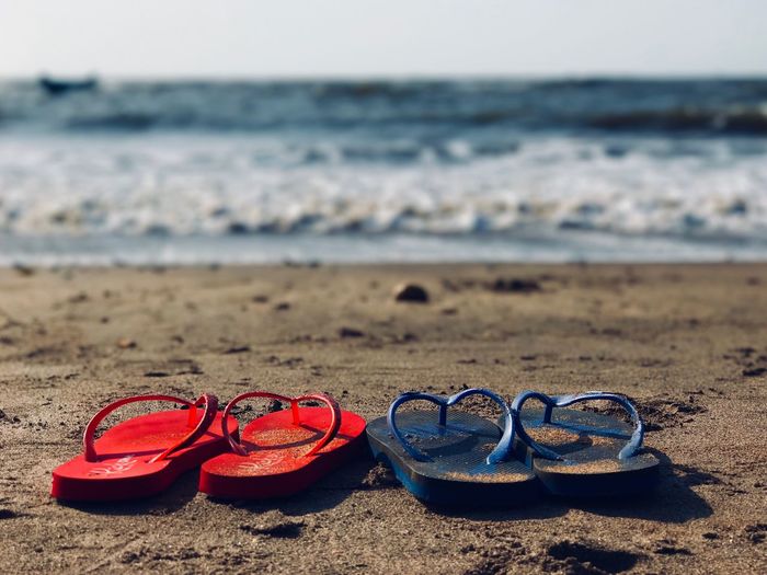 Close-up of flip-flops at beach