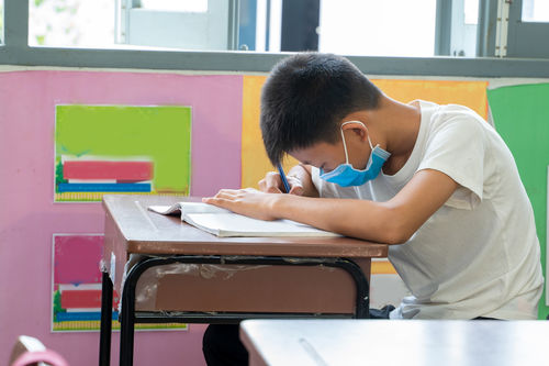 Side view of boy sitting on table