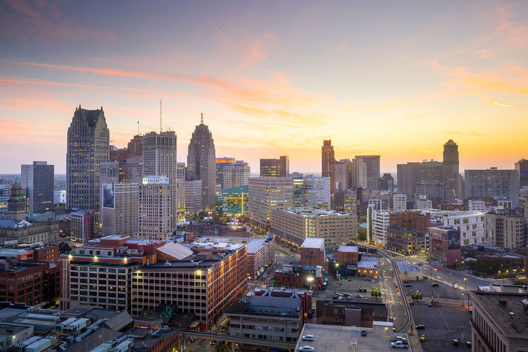 Aerial view of buildings in city against sky during sunset
