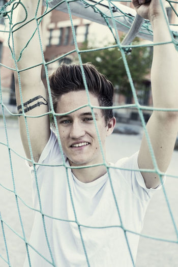 Portrait of smiling high school student behind soccer net