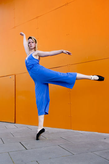 Full length of woman standing against wall