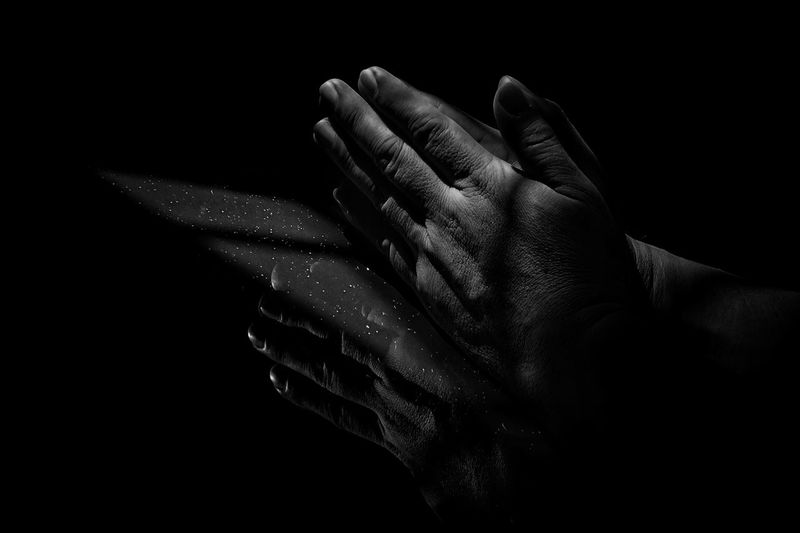 Close-up of hands against black background