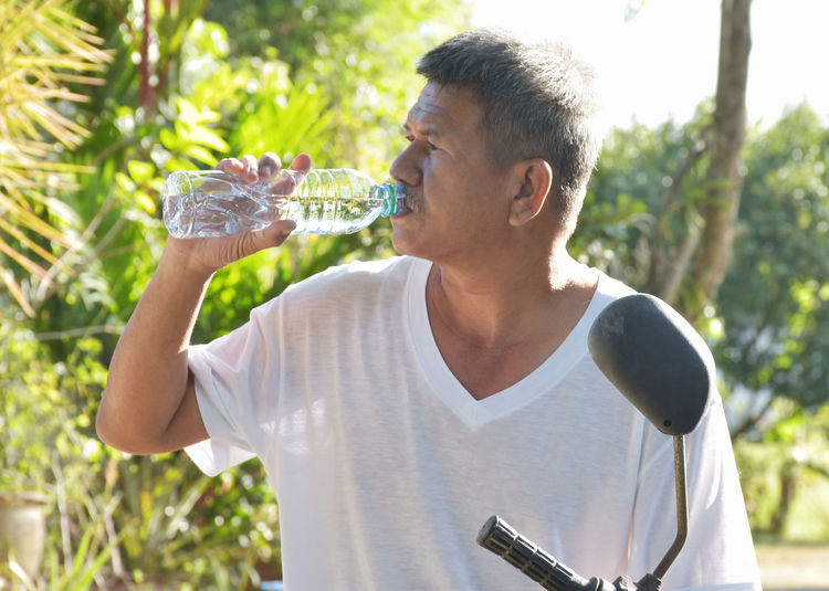 Side view of woman drinking water bottle