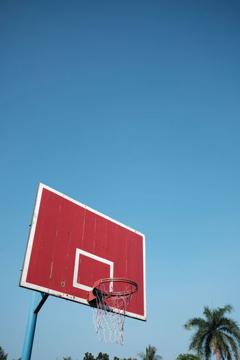Low angle view of basketball hoop against clear blue sky 