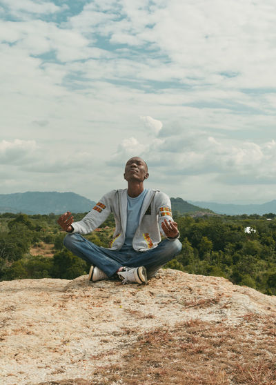 A man sitting on a hill top meditating