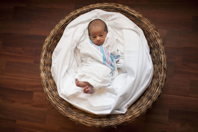 High angle view of baby sleeping in basket