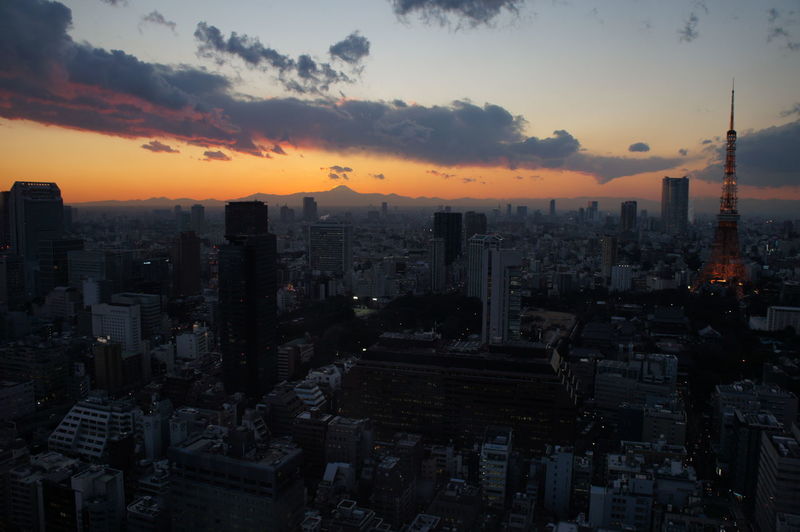 Tokyo tower and modern buildings in city at sunset