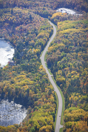 Aerial view of curving road and lakes and trees in northern minnesota on a sunny autumn day