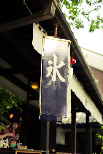 Japanese script on fabric hanging by building