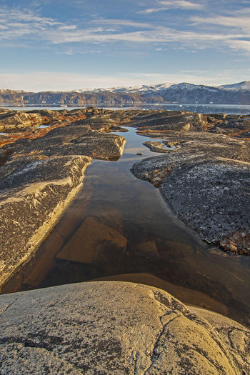 Colorful pond in the barren rock of the arctic near eqip sermia in greenland