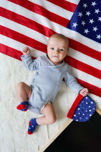 High angle view of baby girl holding american flag