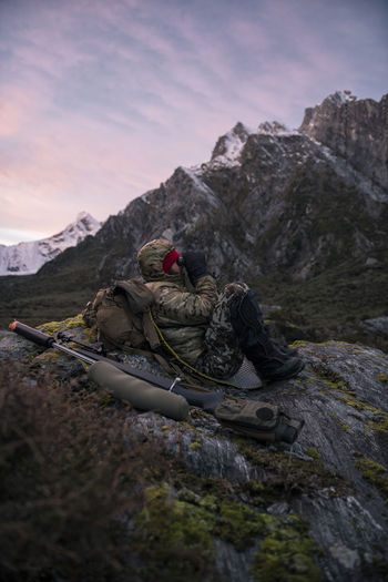 Hunter in mountains looking through binoculars