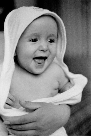 Close-up of smiling baby girl wrapped in towel