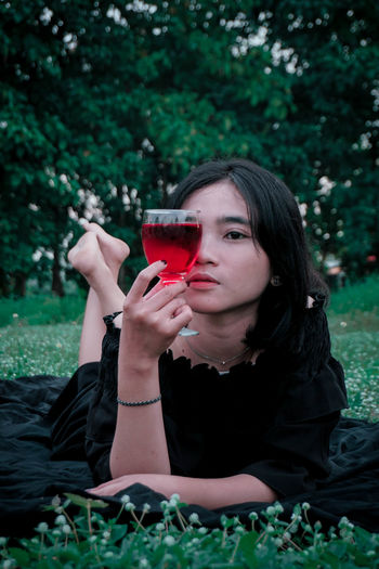 Portrait of a young woman drinking glass