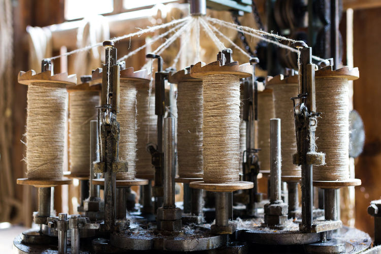 Close-up of spools in machinery at textile industry