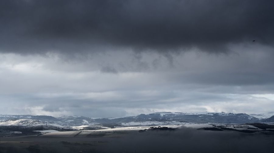 Scenic view of mountains against cloudy sky