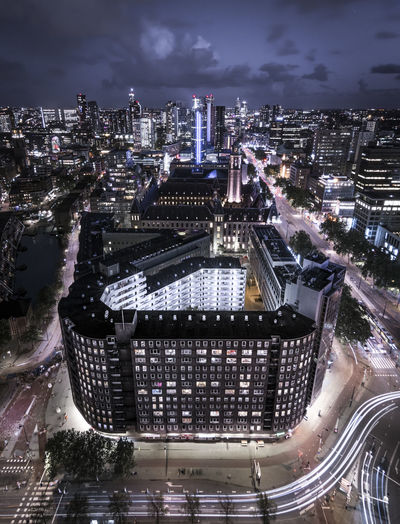 Aerial view of illuminated buildings against sky at night