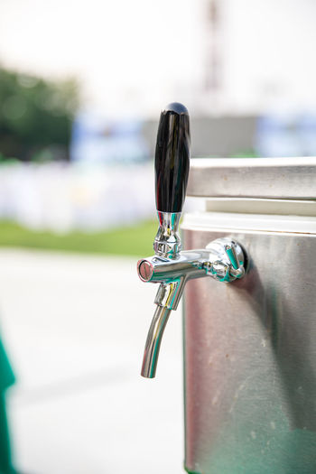 Steel beer tap or faucet at outdoor party in garden